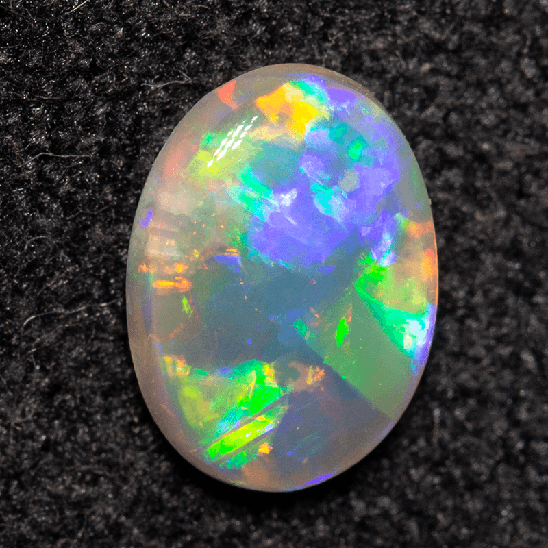 Vibrant opal gemstone displaying a mesmerizing play of colors, featuring flashes of blue, green, and orange